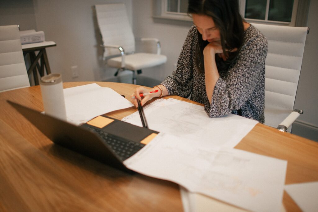 Team member reviewing architectural floor plans in the conference room at The Wilson Company office in Cayce, SC.