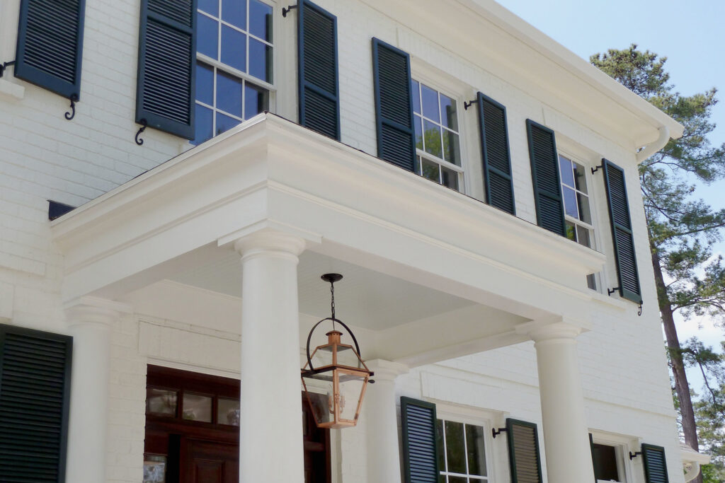 Front porch detail with columns, shutters, and lantern on WilsonCo custom home in Cayce South Carolina