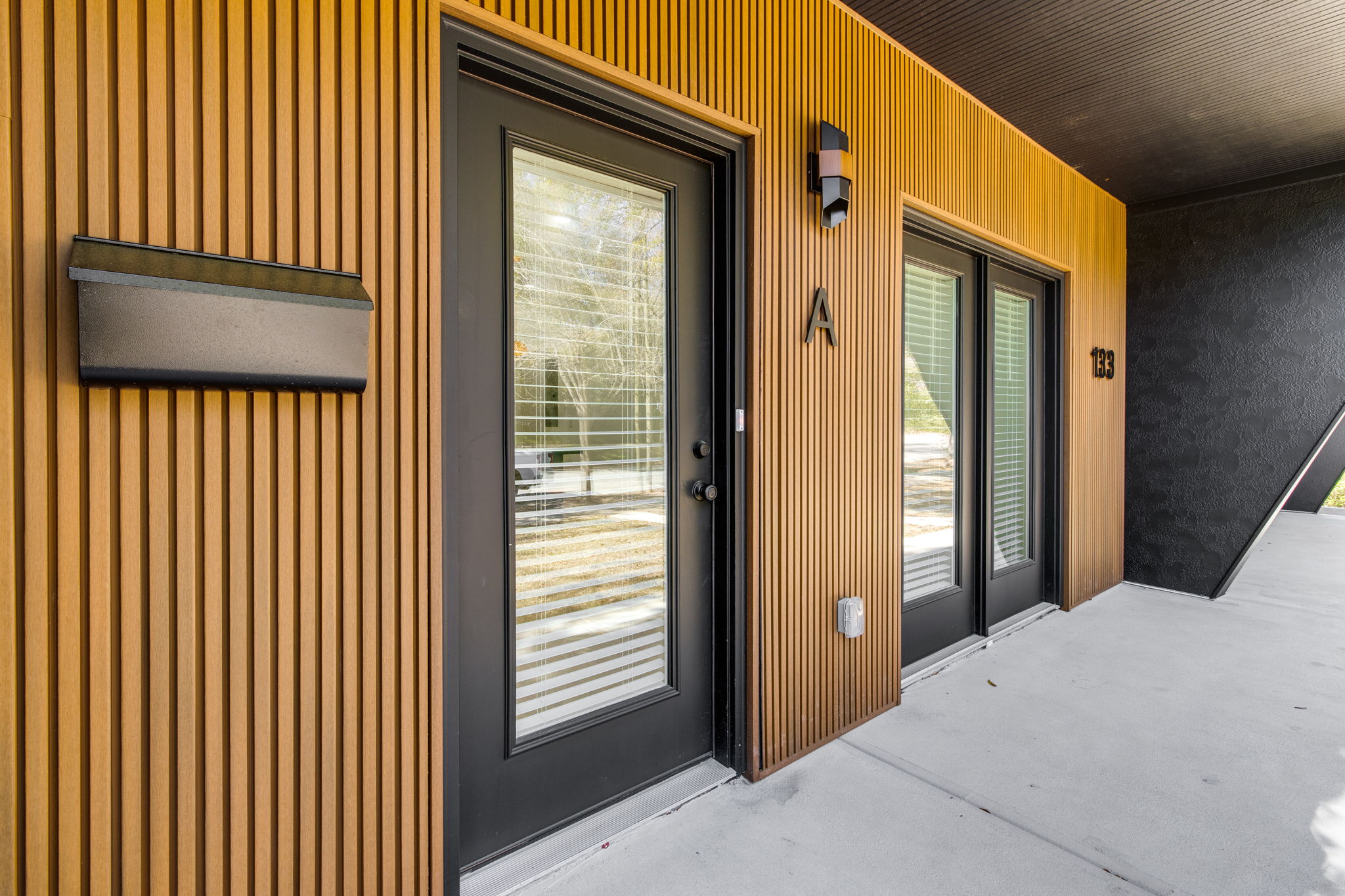 Close-up of WilsonCo built duplex front door with wood slat accent exterior in Cayce South Carolina