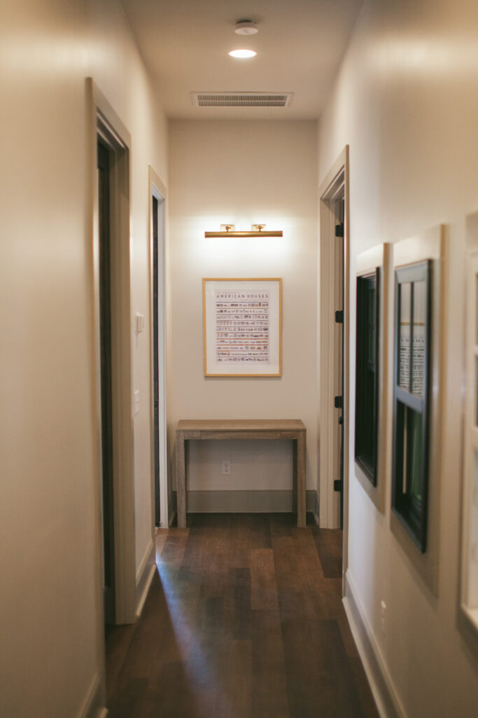 Hallway inside TheWilsonCo Cayce South Carolina office featuring framed American house design artwork
